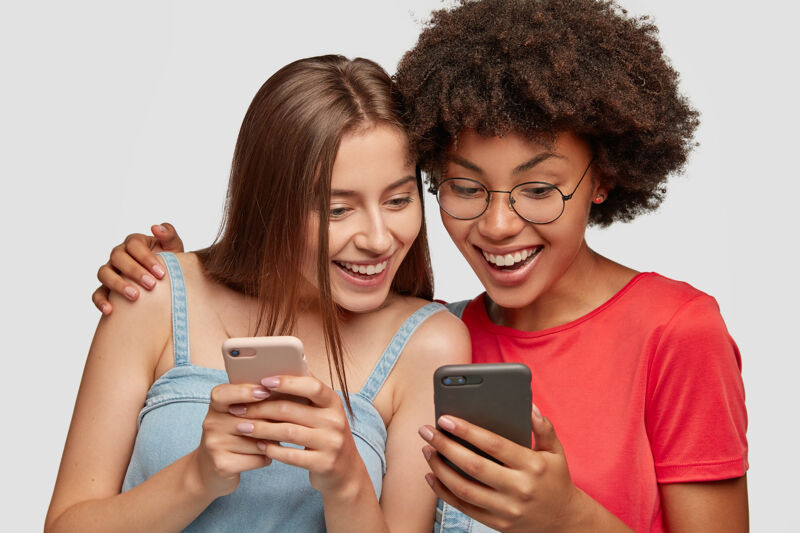 Women discuss something on a phone