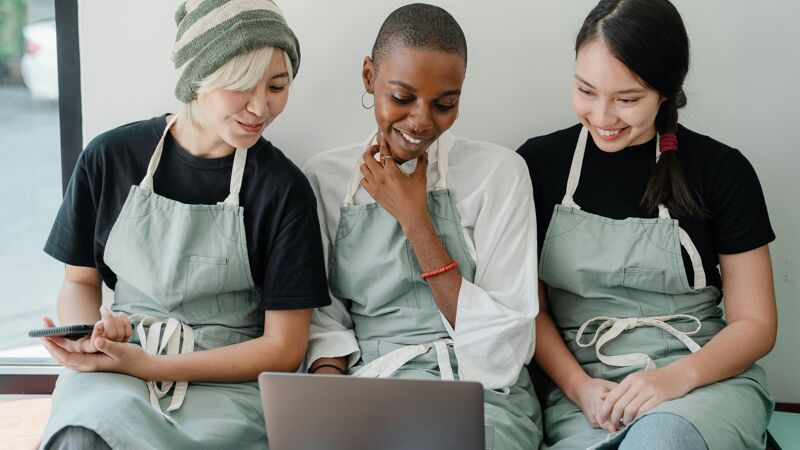 Waitresses using laptop together during a break