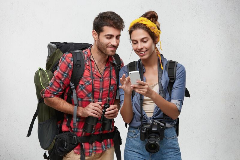 Happy young tourists looking at a phone